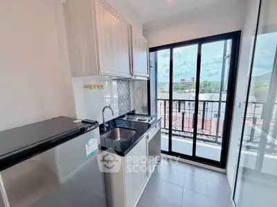 Modern kitchen with sleek design and balcony view in urban apartment