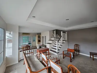 Spacious living room with elegant wooden furniture and modern staircase