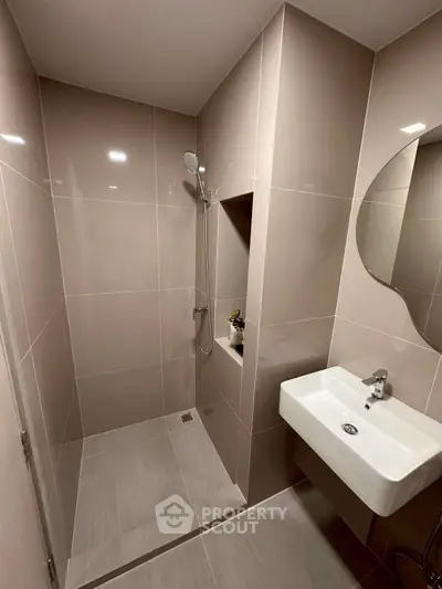 Modern bathroom with sleek shower and stylish sink in contemporary apartment.