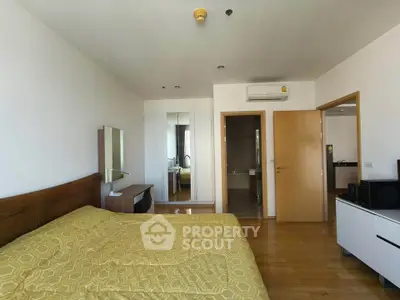 Spacious bedroom with wooden flooring and modern furnishings