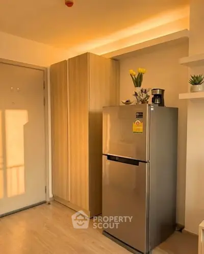 Modern kitchen corner with stainless steel fridge and sleek cabinetry
