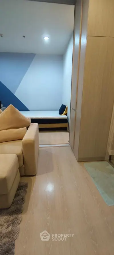 Modern living room with cozy beige sofa and stylish blue accent wall