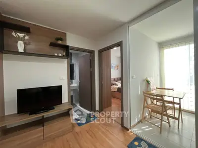 Cozy apartment interior with modern living room and dining area, featuring wooden flooring and natural light.