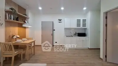 Modern open-layout kitchen and dining area with wooden flooring and stylish decor.