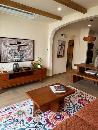 Charming living room with vintage decor, wooden furniture, and colorful rug, perfect for cozy gatherings.
