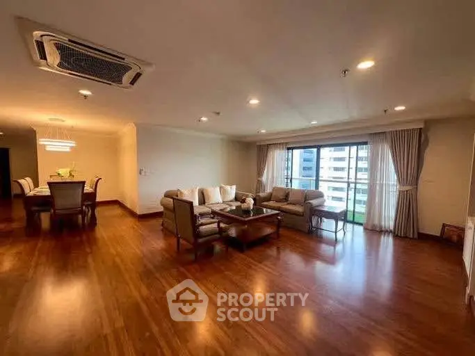 Spacious living room with elegant wooden flooring and modern furniture in a luxury apartment.