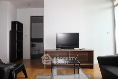 Modern living room with sleek furniture and TV, showcasing minimalist design and natural light.
