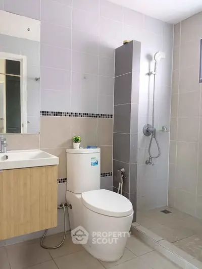 Modern bathroom with sleek design featuring shower and vanity unit