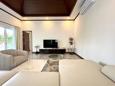 Spacious living room with modern furniture and air conditioning, featuring elegant decor and natural light.