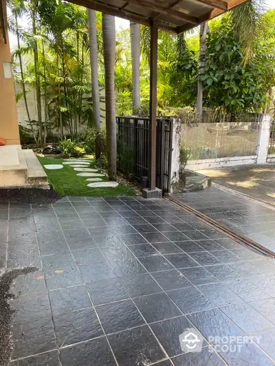 Charming garden entrance with lush greenery and stone pathway