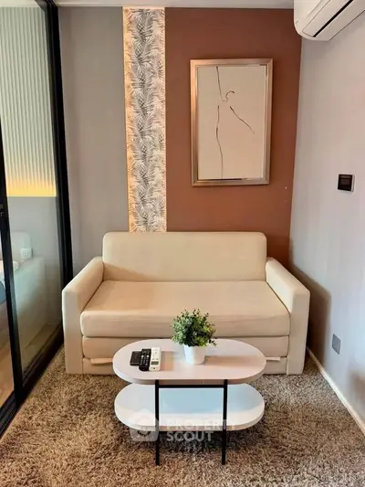 Modern living room with stylish sofa, elegant decor, and cozy ambiance in a contemporary apartment.