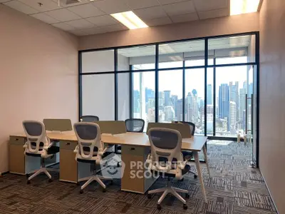 Modern office space with city skyline view, featuring ergonomic chairs and large windows.