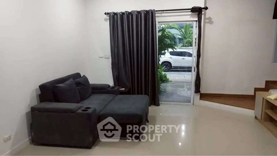 Modern living room with sleek black sofa and large window view