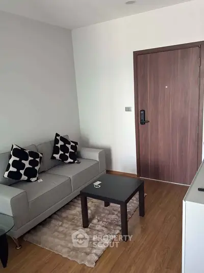 Modern living room with stylish sofa and wooden door, perfect for cozy urban living.