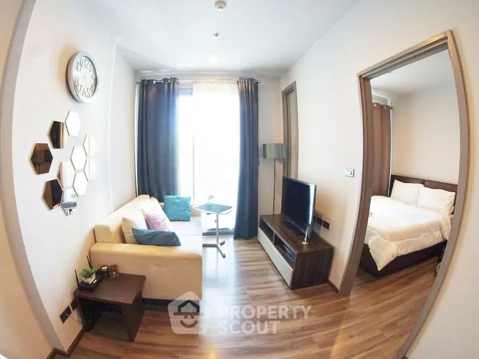 Modern living room with cozy sofa, stylish decor, and adjacent bedroom in a chic apartment.