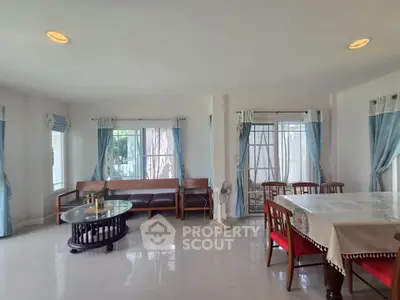 Spacious living room with elegant dining area and natural light