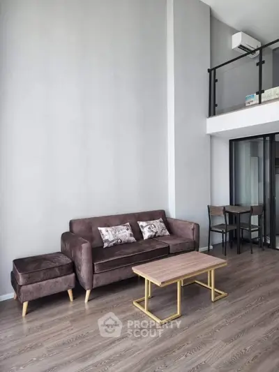 Modern loft-style living room with high ceiling and elegant furniture.
