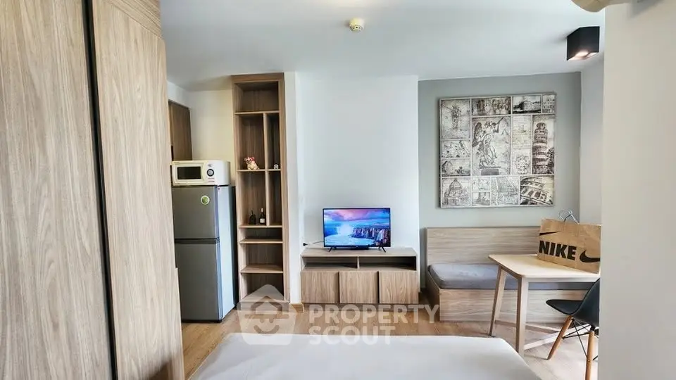 Modern studio apartment with cozy living area and compact kitchen, ideal for urban living.