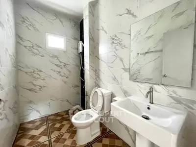 Modern bathroom with marble tiles and sleek fixtures in a contemporary home.