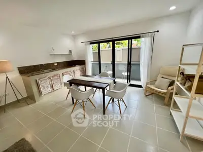 Modern open-layout living room with dining area and balcony access, featuring sleek furniture and natural light.