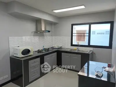 Modern kitchen with sleek cabinetry, gas stove, and microwave in a bright, well-lit space.