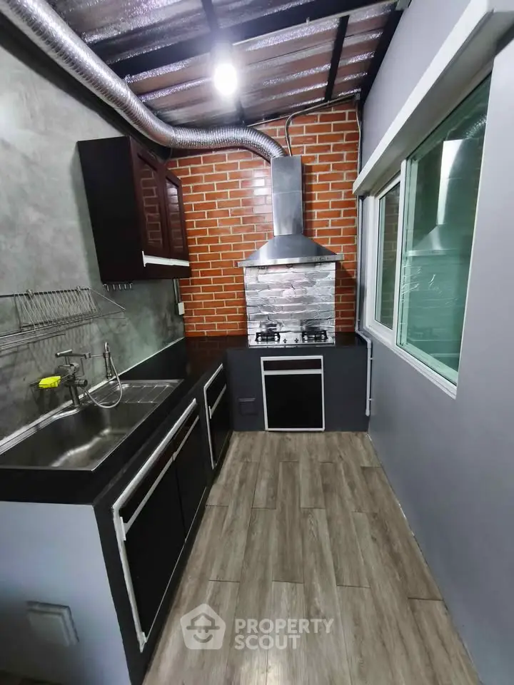 Modern kitchen with sleek design, featuring gas stove and stainless steel sink, perfect for culinary enthusiasts.
