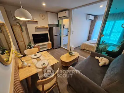 Modern open-plan living room with cozy dining area and view into stylish bedroom