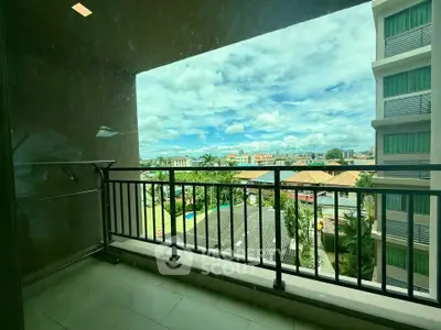 Spacious balcony with stunning city view in modern apartment complex.