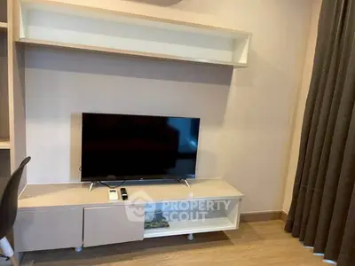 Modern living room with sleek TV stand and wall-mounted shelf, perfect for stylish urban living.