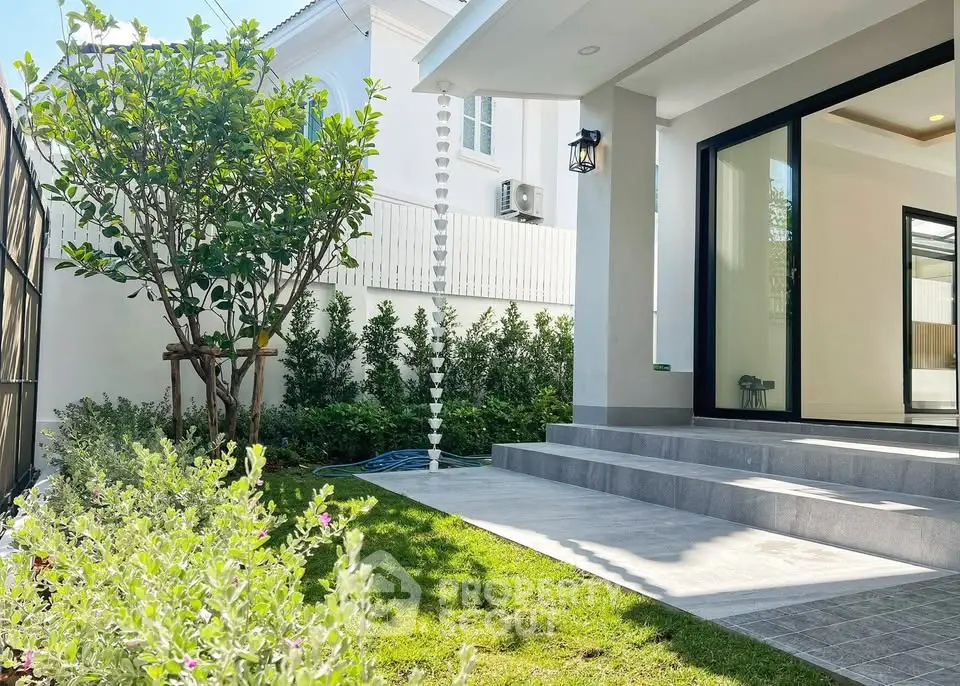 Charming modern home exterior with lush garden and elegant entrance steps