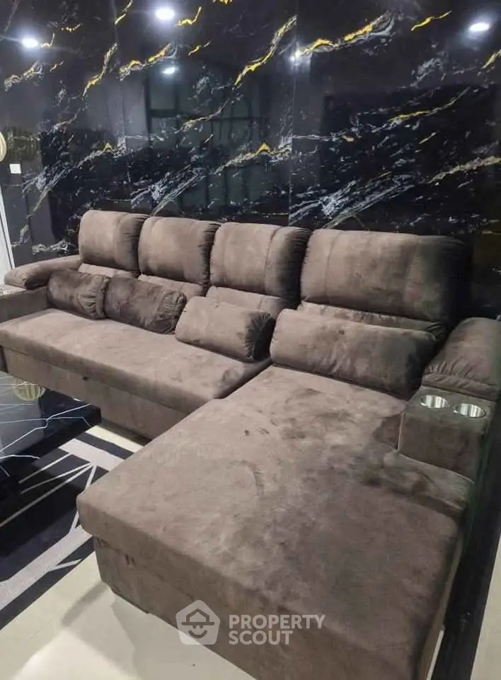Luxurious living room with plush sectional sofa and elegant marble accent wall.