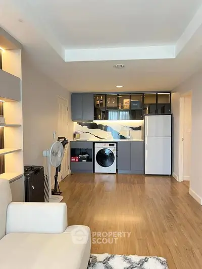 Modern open-plan living room with sleek kitchen appliances and stylish decor