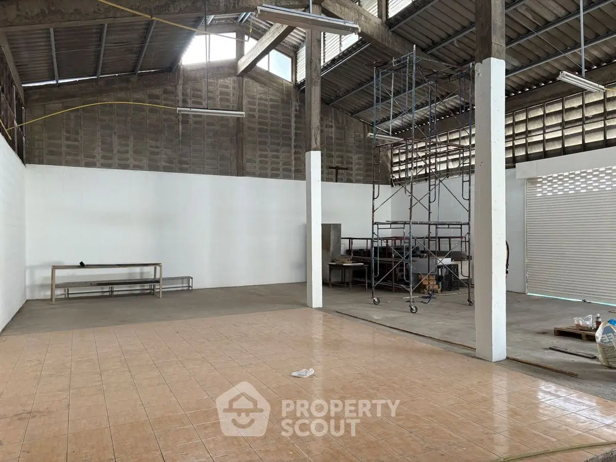 Spacious industrial warehouse with high ceilings and ample natural light.