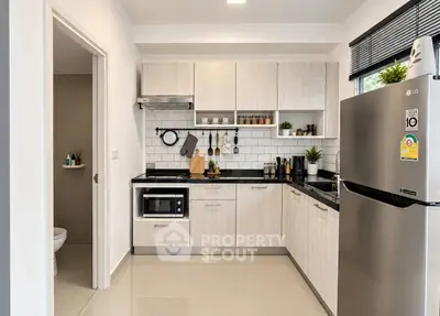 Modern kitchen with sleek cabinetry, stainless steel appliances, and stylish backsplash in a contemporary apartment.