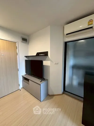 Modern living room with sleek TV stand and air conditioning unit, featuring minimalist design and wooden flooring.