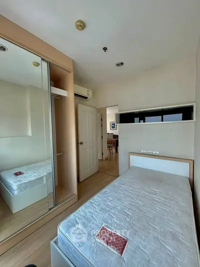 Cozy bedroom with mirrored wardrobe and modern decor in a bright apartment.