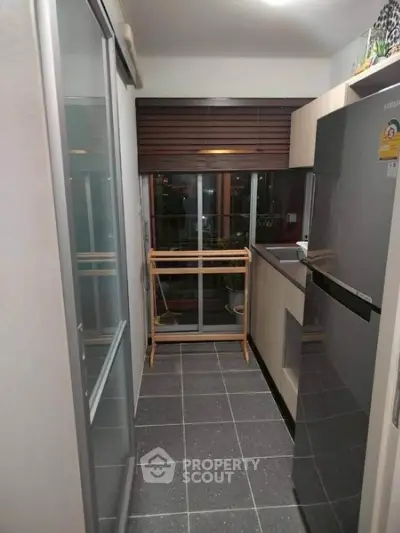 Modern kitchen with sleek appliances and large window for natural light.