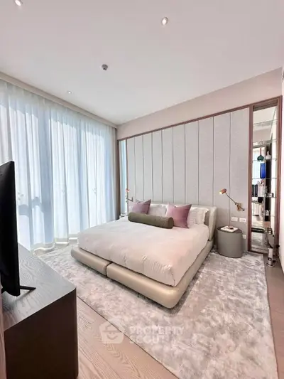 Luxurious bedroom with modern decor and floor-to-ceiling windows in upscale apartment.