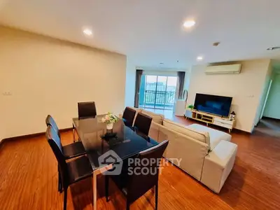 Spacious living room with modern dining area and balcony view