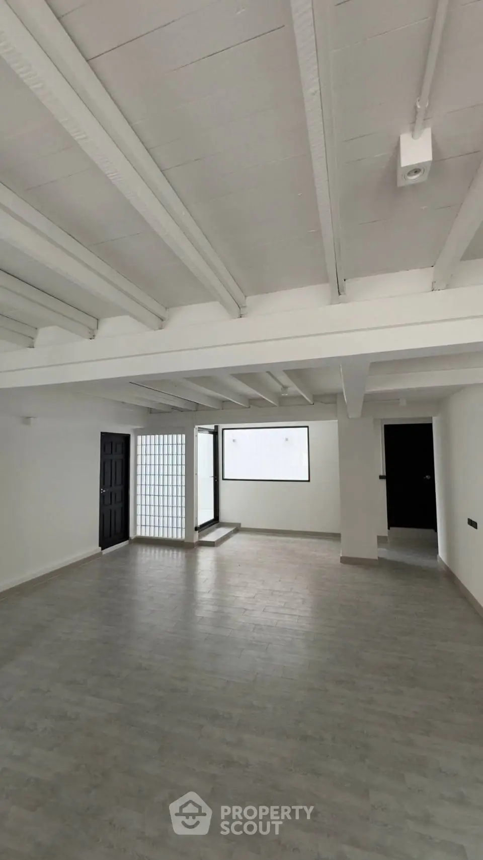 Expansive open-plan living space with high ceilings, large windows, and sleek flooring, ideal for customization in a modern urban home.