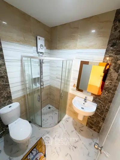 Modern bathroom with glass shower, sleek fixtures, and elegant tile design.