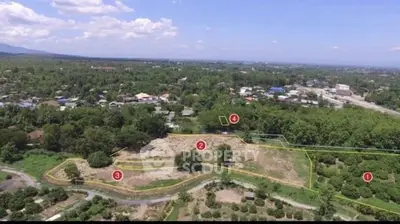 Expansive aerial view of prime real estate land with lush greenery and clear skies, ideal for development.