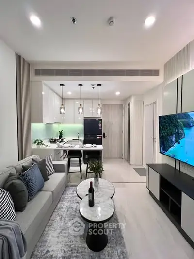 Modern living room with open kitchen, stylish decor, and cozy ambiance.