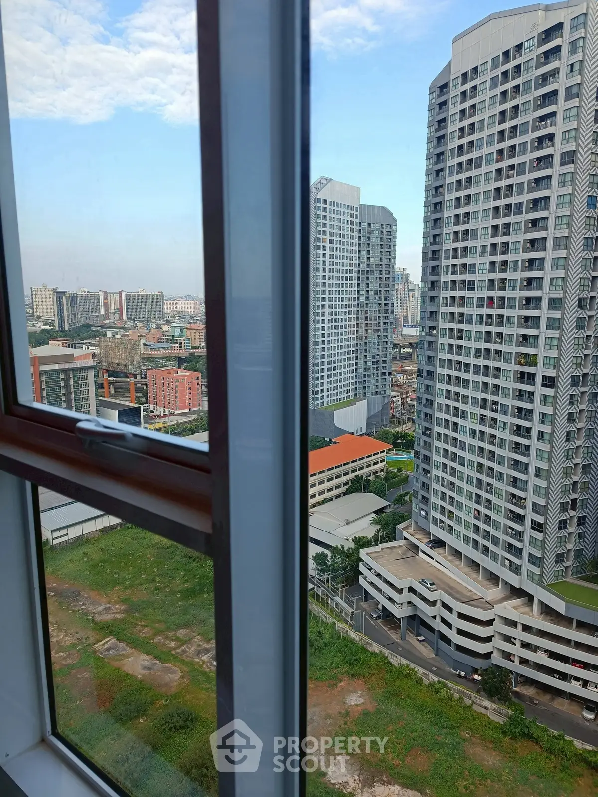Stunning cityscape view from high-rise apartment window, showcasing modern urban living.
