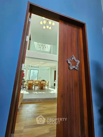 Elegant entrance to a modern home with wooden door and stylish interior view.