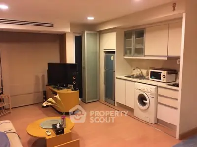 Modern studio apartment with compact kitchen and washing machine