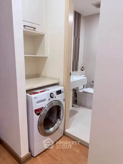 Compact bathroom with integrated washing machine and modern fixtures.