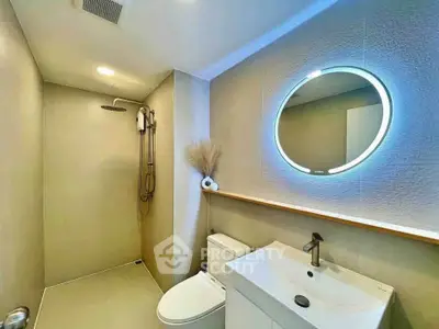 Modern bathroom with sleek shower and illuminated mirror