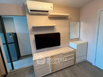 Modern living room with sleek wooden furniture and wall-mounted TV, featuring air conditioning and minimalist decor.