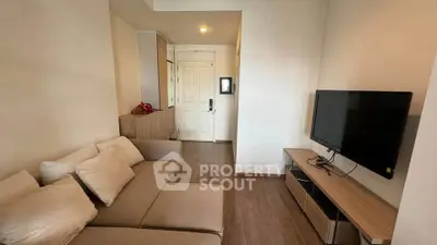 Modern living room with cozy beige sofa and flat-screen TV, perfect for relaxation.